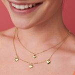 El-collar-para-mujer-es-de-material-metalico-en-dos-niveles-con-dijes-de-corazon-y-bañado-en-oro.-